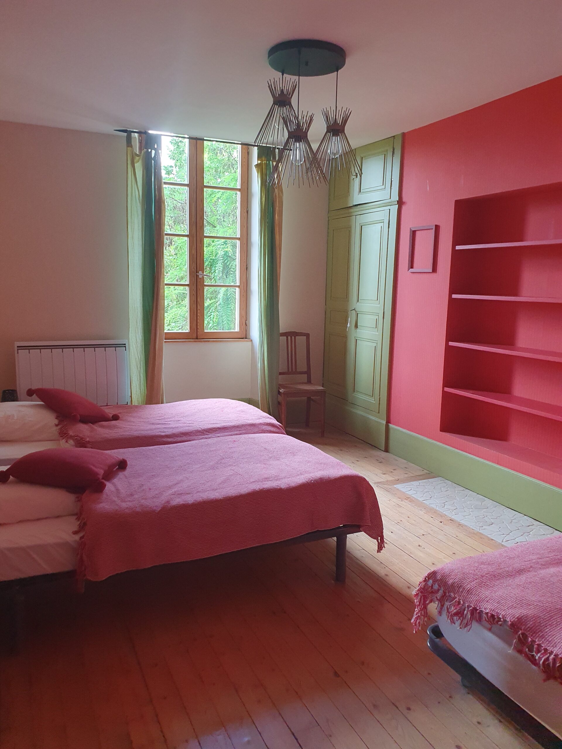 Chambre rouge avec 3 lits